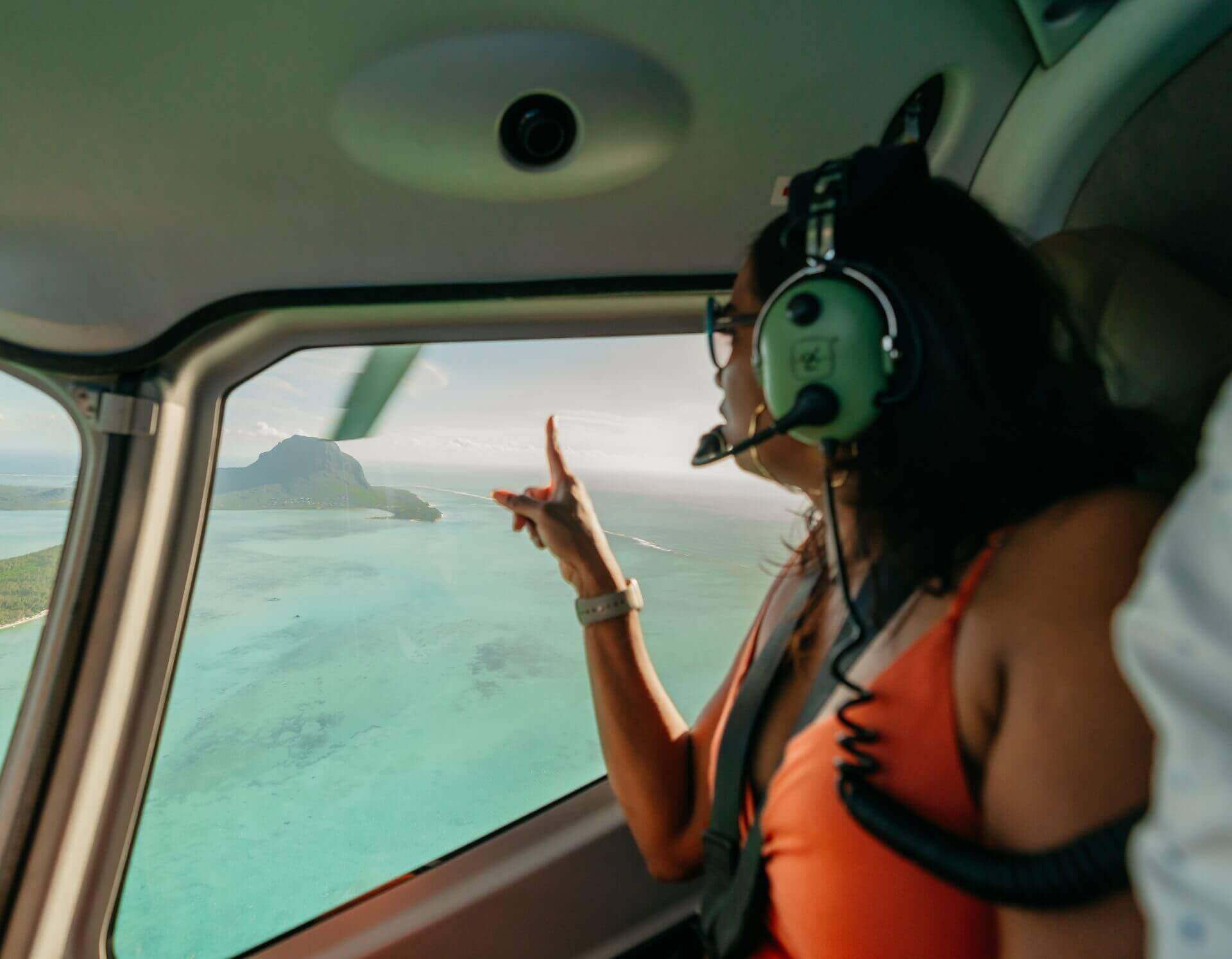 Woman admiring the underwater waterfall in Mauritius from a helicopter